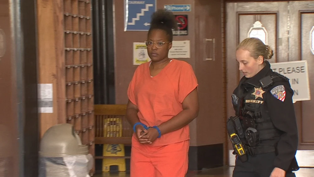 Tyesha Long entering an Oklahoma courtroom in custody, escorted by a sheriff's deputy